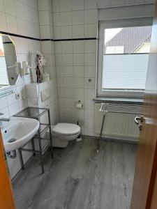 a bathroom with a toilet and a sink and a window at Boddenwind FW 2 in Zingst