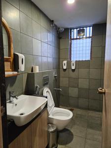 a bathroom with a white toilet and a sink at Hotel Tattva Suites in Pune