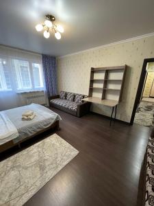 Habitación con 2 camas y sofá. en Просторная квартира в жк Науаи около ТРЦ МЕГА, en Almaty