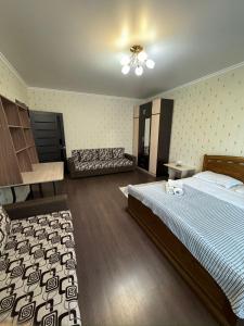 1 dormitorio grande con 1 cama y 1 sofá en Просторная квартира в жк Науаи около ТРЦ МЕГА, en Almaty