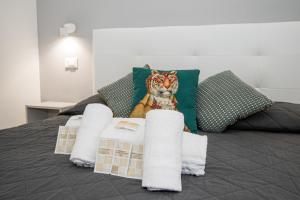 un tigre farci assis sur un lit avec des serviettes dans l'établissement Room 23, à Rome