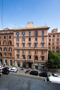 a large pink building with cars parked in front of it at Room 23 in Rome