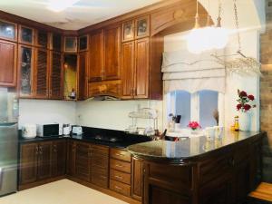 a kitchen with wooden cabinets and a marble counter top at Rose's House Hue in Hue