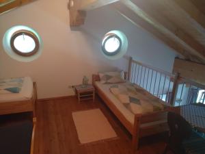 a bedroom with a bed and two windows at Arbeiterwohnung Entbuchner Hof in Rohrdorf