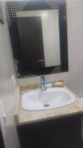y baño con lavabo y espejo. en Suite ICON, en Quito