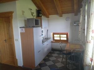 a kitchen with a refrigerator and a sink and a table at Arbeiterwohnung Entbuchner Hof in Rohrdorf +2 photos