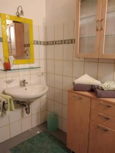 La salle de bains est pourvue d'un lavabo et d'un miroir. dans l'établissement Arbeiterwohnung Entbuchner Hof, à Rohrdorf