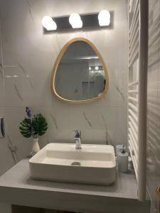 uma casa de banho com um lavatório branco e um espelho. em Villa Sunset em Argostólion