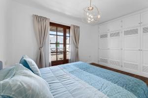 a bedroom with a bed and a chandelier at Casa Lily Lanzarote a 5 min del mar in Playa Honda