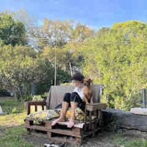 une personne assise sur une table avec un chien dans l'établissement POGGIO ROSETO, à Randazzo