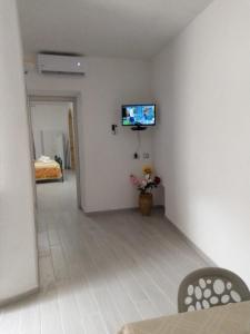 een woonkamer met een tv aan een witte muur bij Dimora del Malconsiglio in Miglionico