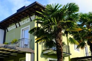 a palm tree in front of a yellow building at Residenza Laurum in Mandello del Lario