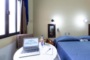 a room with a bed and a laptop on a table at Daher Center Hotel in São Paulo