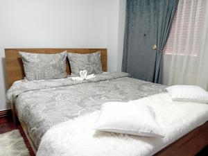 - une chambre avec un lit doté de draps et d'oreillers blancs dans l'établissement PERLA PREMIUM APARTMENT, à Timişoara