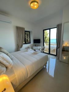 a bedroom with a large bed with a view of the ocean at Hôtel Le Roquebrune in Roquebrune-Cap-Martin