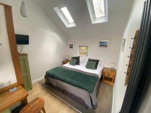 a bedroom with a bed in a room with skylights at Claremont House Keswick in Keswick