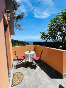 a patio with a table and two chairs on a balcony at Cozy House in Funchal