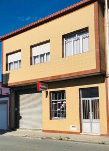 un edificio con due porte garage su una strada di Casa CHORIMA a Arzúa