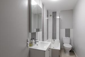 a white bathroom with a sink and a toilet at Stunning Flat 5 min from Station in London