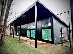 a black house with windows on the side of it at Big Cat Bungalows at The Haven in Chittenango