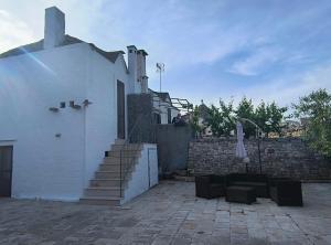 ein weißes Haus mit Treppen und Ziegelwand in der Unterkunft Tipico Resort in Alberobello