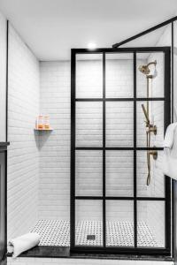 a shower with a glass door in a bathroom at Historic Hotel, King Bed, Fast WiFi, Room # 104 in Bangor