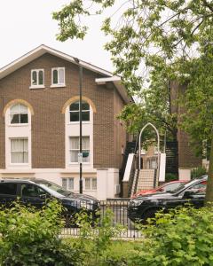 a brick building with cars parked in a parking lot at Stunning Flat 5 min from Station in London