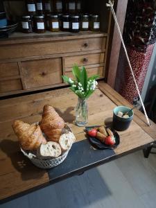 - une table avec un plateau de pain et un vase de fleurs dans l'établissement LA PAUSE, à Surville