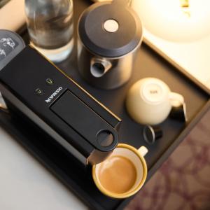 a cell phone with a cup of coffee on a table at Blandford Hotel in London