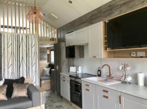 a kitchen with white cabinets and a couch in a room at Self-Catering Lodge with Hot Tub in Inverness