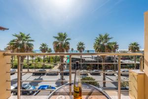 a glass table on a balcony with a view of a parking lot at Amazing beachfront Oasis in Durrës