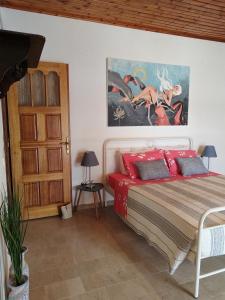 a bedroom with a bed and a painting on the wall at The Pergola Cottage...Feel the local vibes! in Perivolion