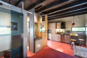 une cuisine ouverte avec des plafonds en bois et du parquet rouge dans l'établissement Casa Tamì, à Viagrande