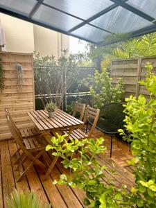 patio z drewnianym stołem i krzesłami w obiekcie Appart-hôtel64 Bayonne w Bajonnie