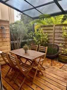 a wooden table and chairs on a wooden deck at Appart-hôtel64 Bayonne in Bayonne