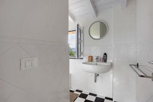 bagno bianco con lavandino e specchio di Casa Conte Picedi Vineyars ad Arcola