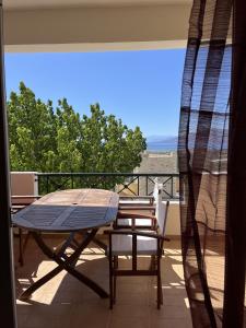 a table and chairs on a balcony with a view at Spitiko in Kamilari +23 photos