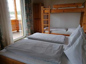 Ce dortoir comprend 2 lits superposés et une fenêtre. dans l'établissement Bauernhof-Pension Puschnikhof, à Unternarrach