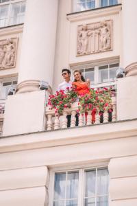 mężczyzna i kobieta siedzący na balkonie w obiekcie Esplanade Zagreb Hotel w Zagrzebiu