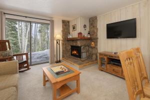 a living room with a fireplace and a television at Beaver Village Unit #0712R in Winter Park +17 photos