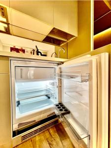 an empty refrigerator with its door open in a kitchen at Sunshine Apartments Batumi Lux in Batumi