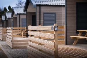 a row of wooden homes on a deck at Self-Catering Lodge with Hot Tub in Inverness