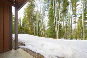 a snow covered porch with a view of a forest at Beaver Village Unit #0712R in Winter Park