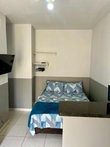 um quarto com uma cama com lençóis azuis e brancos em Casa da Vó Maria! Studio 08 em Goiânia