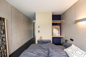 a bedroom with a bed and a wall at FRIZ Art in Gundelfingen