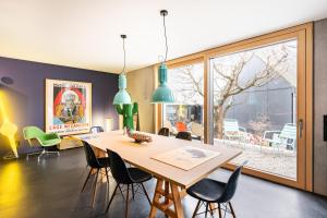 a dining room with a table and chairs and a large window at FRIZ Art in Gundelfingen