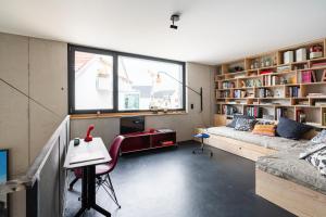 ein Wohnzimmer mit einem Sofa, einem Tisch und einem Schreibtisch in der Unterkunft FRIZ Art in Gundelfingen
