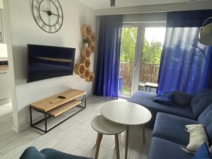 sala de estar con sofá azul y mesa en Apartament Parking & Balkon, en Wroclaw