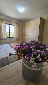 a bedroom with a large pot of purple and white flowers at Ela Apartments 1 in Tirana