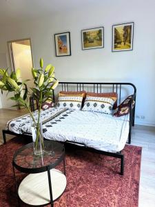 Ce lit se trouve dans un dortoir doté d'un vase sur une table. dans l'établissement Charme et Passion By UTA HOUSE, à Saint-Denis